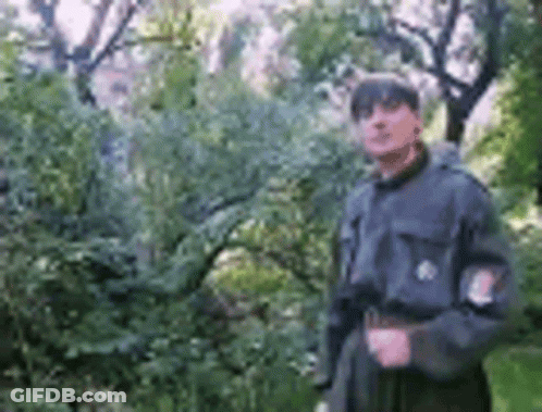 Man In Military Uniform Standing By Tree GIF