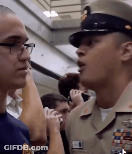 Man In Military Uniform Talking To Glasses Man GIF