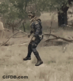 Man In Military Uniform Walking In Grass GIF