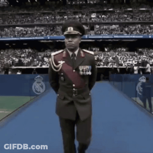 Man In Military Uniform Walking On Blue Carpet GIF