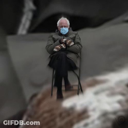 Man In Mittens And Face Mask Sitting In Chair GIF