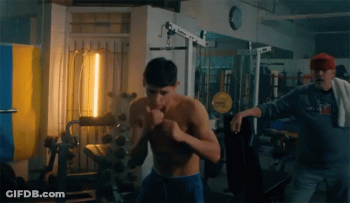 Man In Moscow Sweatshirt Next To Shirtless Man GIF