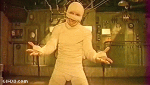 Man In Mummy Costume In Front Of Wall Number 99 GIF