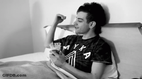 Man In Myka Shirt Laying On Bed GIF