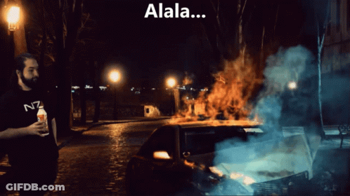 Man In N7 Shirt In Front Of Burning Car At Night GIF