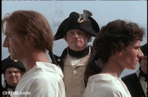 Man In Napoleonic Hat Between Two Men In White Shirts GIF