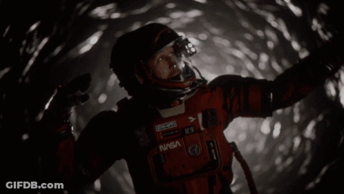 Man In NASA Space Suit Standing In Dark Tunnel GIF