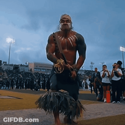 Man In Native American Costume Standing On Field GIF