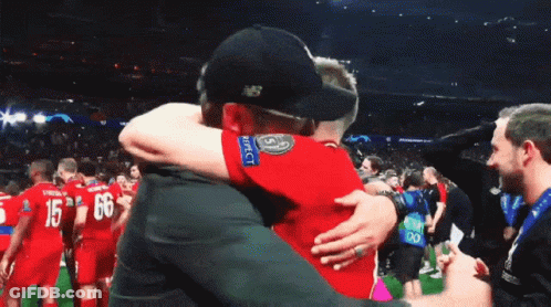 Man In New Balance Hat Hugging Another Man GIF