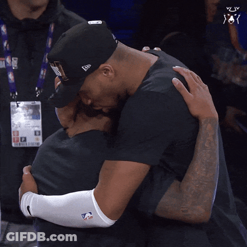Man In New Era Hat Hugging Man In Black Shirt GIF