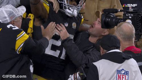 Man In NFL Jacket Holding Football Player's Chest GIF