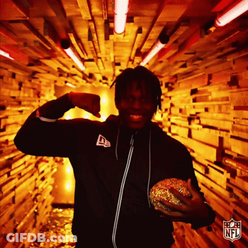 Man In NFL Jacket Holding Hamburger In Tunnel GIF