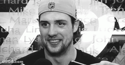 Man In NHL Hat In Front Of Wall Of Names GIF