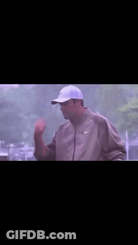 Man In Nike Jacket Holding Frisbee Over Head GIF