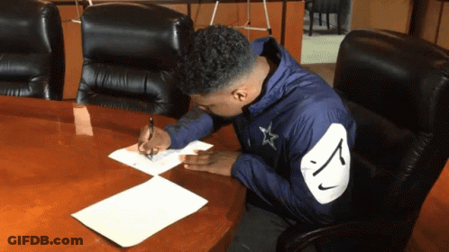 Man In Nike Jacket Writing At Conference Table GIF