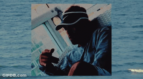 Man In Nike Visor Sitting By Water GIF
