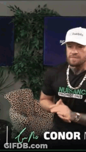 Man In Nuisanc T-Shirt Sitting GIF