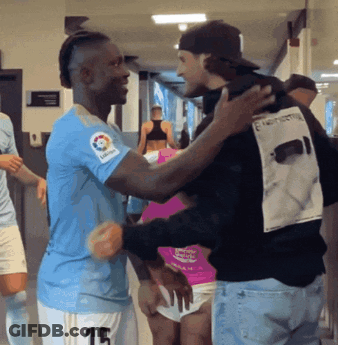 Man In Number 15 Jersey Hugging Man In Black Shirt GIF