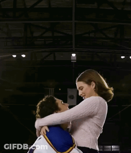 Man In Number 4 Jersey Holding Woman GIF
