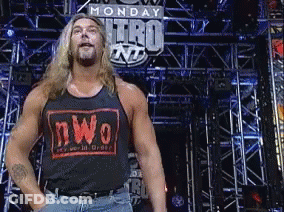 Man In NWO Tank Top Stands In Front Of Monday Nitro Sign GIF