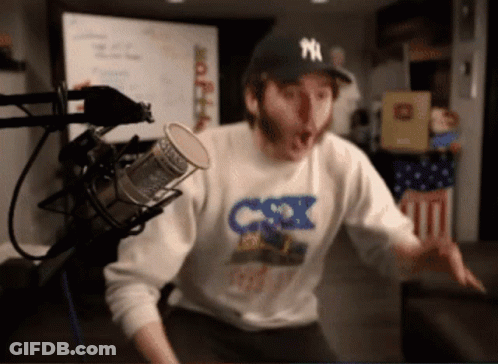 Man In NY Hat At Microphone GIF