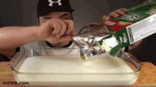 Man In NY Hat Pouring Milk Into Glass Dish GIF
