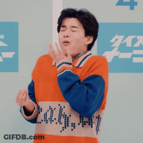 Man In Orange And Blue Sweater Making Funny Face GIF