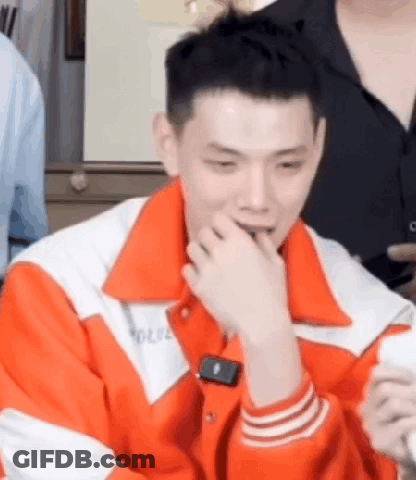 Man In Orange And White Jacket Sitting GIF