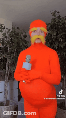 Man In Orange Costume Holding Microphone GIF