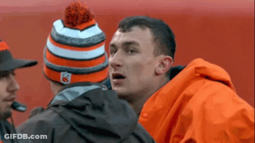 Man In Orange Jacket And Hat Talking To Another Man GIF