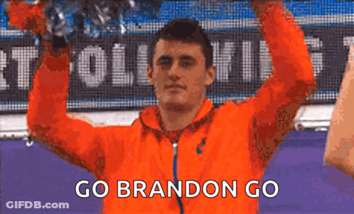 Man In Orange Jacket Holding Trophy Saying Go Brandon Go GIF