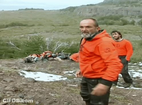 Man In Orange Jacket On Hillside GIF