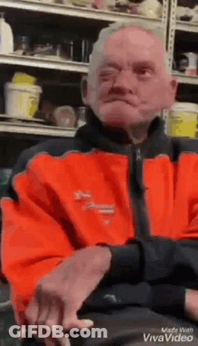Man In Orange Jacket Sitting GIF