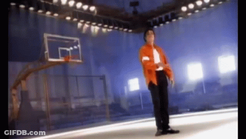 Man In Orange Jacket Standing In Front Of Basketball Hoop GIF