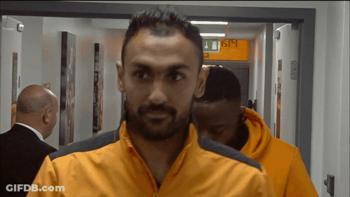 Man In Orange Jacket Walking Past 619 Sign GIF
