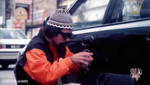 Man In Orange Jacket Working On Car With Swag Sign GIF