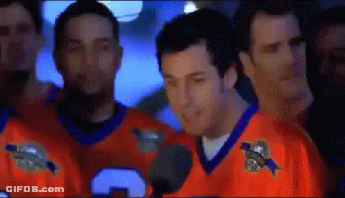 Man In Orange Jersey Talking Into Microphone With Men GIF