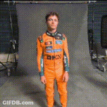 Man In Orange Jumpsuit Standing In Front Of Wall GIF