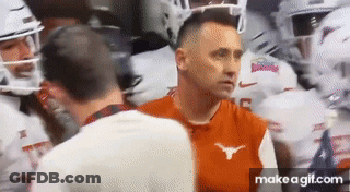 Man In Orange Longhorn Shirt Talking To Man In White Shirt GIF
