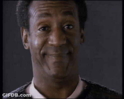 Man In Orange Playerz 69 Jacket Sitting At Table With Other Men GIF