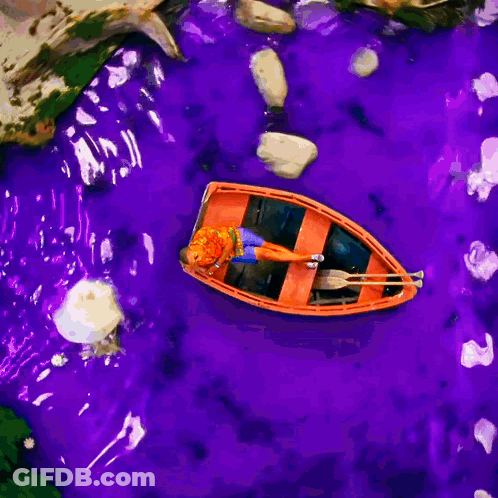 Man In Orange Shirt And Blue Shorts Laying On Boat GIF