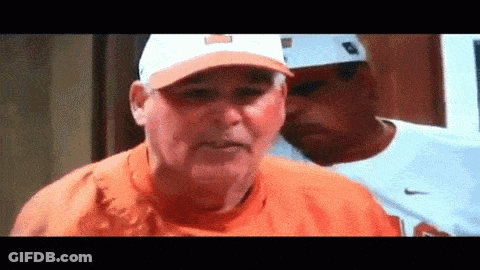 Man In Orange Shirt And Hat Beside Nike Shirt Man GIF