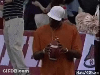 Man In Orange Shirt And White Hat Holding Football GIF
