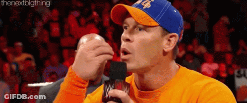 Man In Orange Shirt Blue Hat On Mic GIF