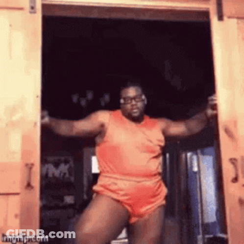 Man In Orange Shirt Dancing In Doorway GIF