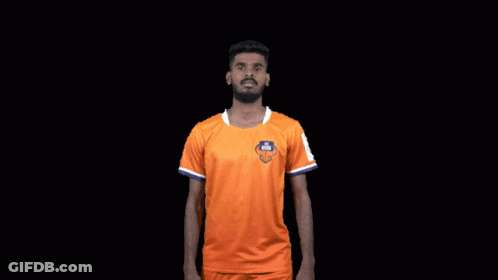 Man In Orange Shirt Flexing Muscles Saying FC Goa GIF