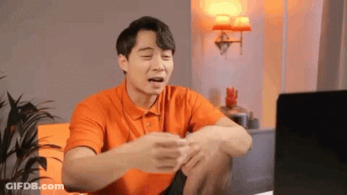 Man In Orange Shirt Funny Face At Computer GIF