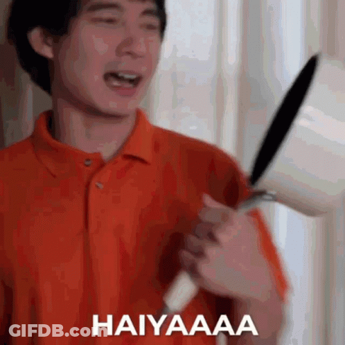 Man In Orange Shirt Holding Frying Pan GIF