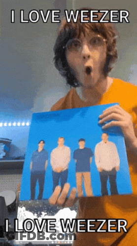 Man In Orange Shirt Holding Weezer Picture GIF
