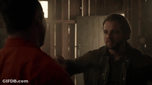 Man In Orange Shirt Hugging Man In Grey Shirt GIF